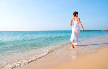 Fototapeta na wymiar Woman walking on beach