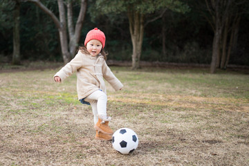 サッカーをして遊ぶ少女