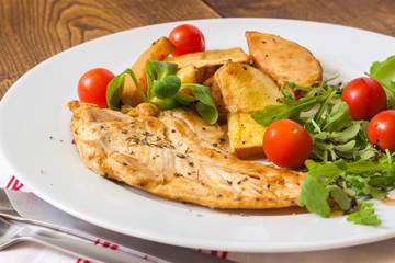 Slices of grilled chicken steak with potatoes and vegetables