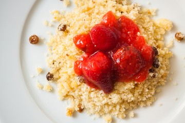 Morsels with strawberry jam on white plate, closeup, top view