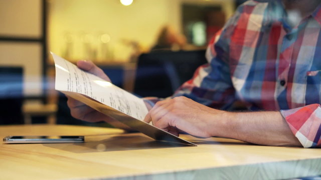 Man reading food menu sitting in cafe