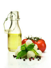 Oil , tomatoes, mozzarella and basil isolated on white