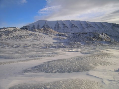 Glacier surface surrounded by mountains in high-Arctic