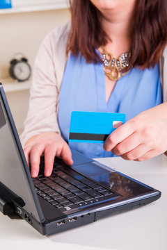 Woman paying by credit card using a computer and the Internet in