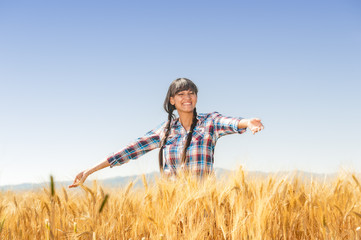 Smiling beautiful young brazilian girl on a yellow crop field