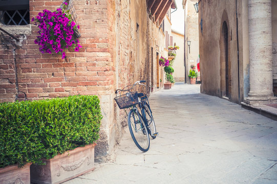 Black vintage bicycle left on a street in Tuscany, Italy