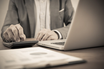 Businessman analyzing investment charts with laptop. Accounting