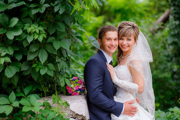 the bride and groom walk in the park