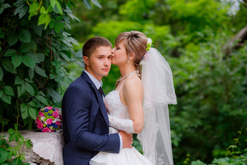 the bride and groom walk in the park
