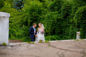 the bride and groom walk in the park