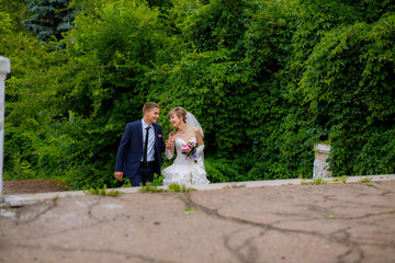 the bride and groom walk in the park