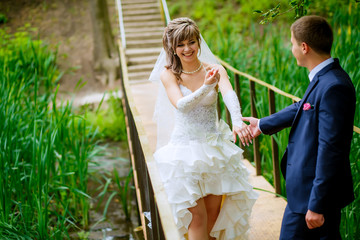 the bride and groom walk in the park