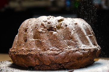 Puderzucker streuen auf Gugelhupf