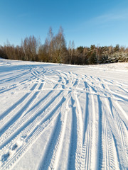 snowy winter road with tire markings