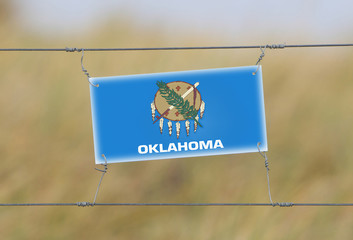 Border fence - Old plastic sign with a flag