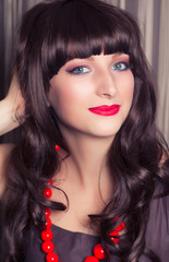 Fototapeta premium beautiful young woman posing with red lace umbrella against retr