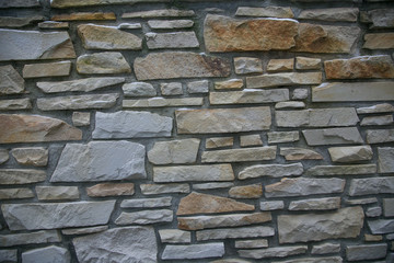 A dry stone wall made of random grey stone. wall of stones 