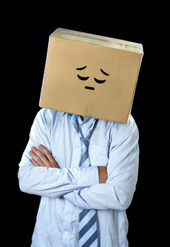 sad businessman wearing smiley face on box over his head