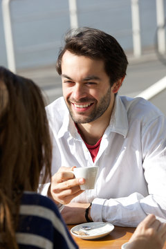Happy young man drinking coffee with woman