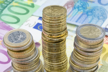 Euromünzen gestapelt auf Banknoten