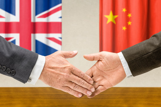 Vertreter Großbritanniens und Chinas reichen sich die Hand