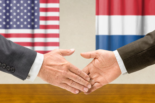 Vertreter der USA und der Niederlande reichen sich die Hand
