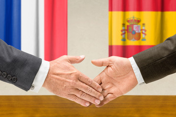 Vertreter Frankreichs und Spaniens reichen sich die Hand