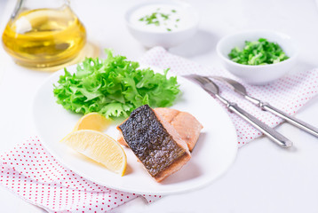 Grilled red fish fillet with lemon and green salad