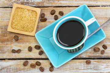 Cup of coffee and brown sugar on rustic wooden surface
