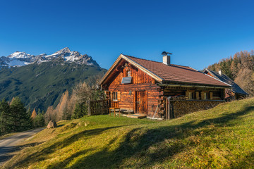 Naklejka premium old wooden hut cabin in mountain alps at rural fall landscape