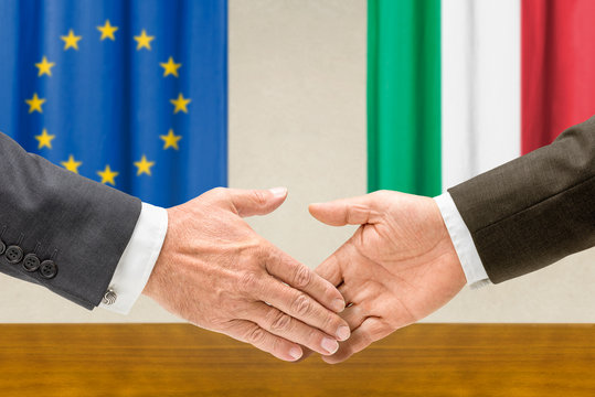 Vertreter der EU und Italiens reichen sich die Hand