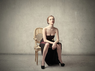 Obraz na płótnie Canvas Classy woman sitting on a chair