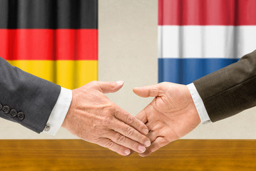 Vertreter Deutschlands und der Niederlande reichen sich die Hand