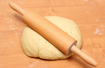 Yeast cake and rolling pin on wooden table