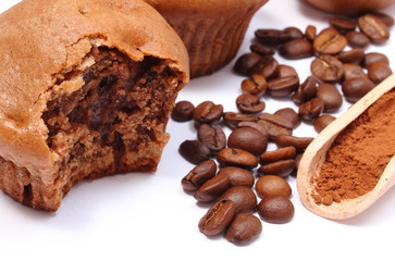Fresh baked muffins, coffee grains and powdery cinnamon