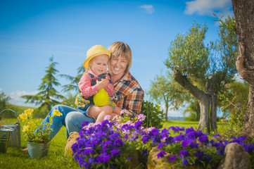 Little girl working with her mother in the garden