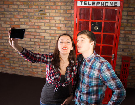 Tourists posing in front of a British phone booth
