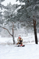 Fototapeta na wymiar Child sledding in winter