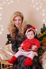 Fototapeta na wymiar Mother and baby girl as santa helper at Christmas