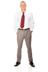 Full length businessman with hands in pockets