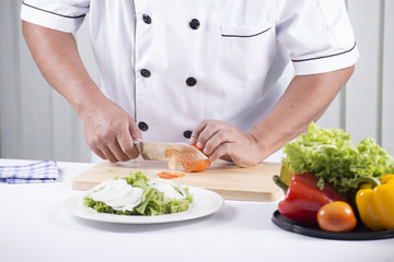 Obraz na płótnie Canvas Chef's hands cutting Tomato