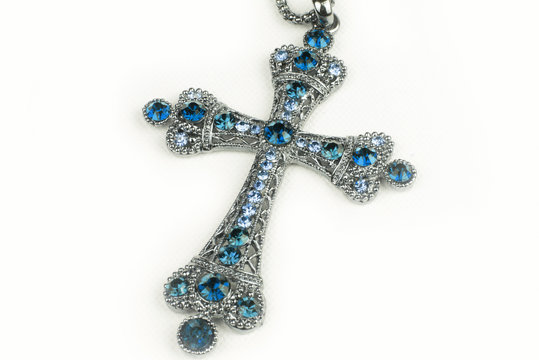 Blue cross necklace in a studio (background, wallpaper)
