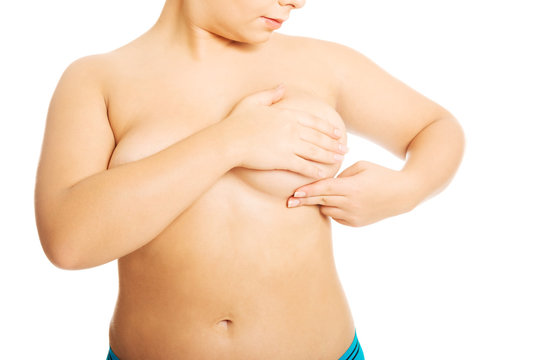 Overweight woman examining her breast