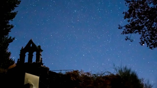 Time lapse, campanario bajo las estrellas