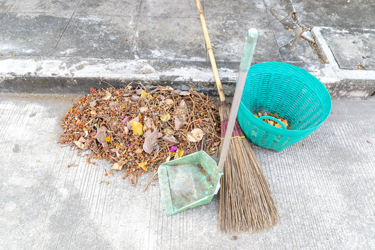 Sweeping Dry leaves, broom, waste scoop on footpath