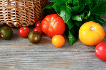 Different types of tomatoes with basil leaves