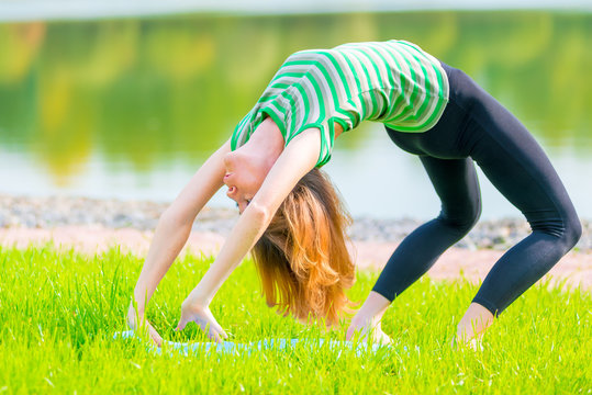 flexible athlete makes a bridge in nature