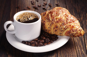 Cup of coffee and croissant with cheese