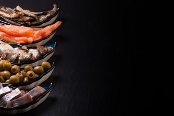Assorty of fish and olives on oriental dish