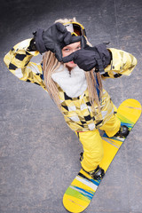 Beautiful woman standing on snowboard